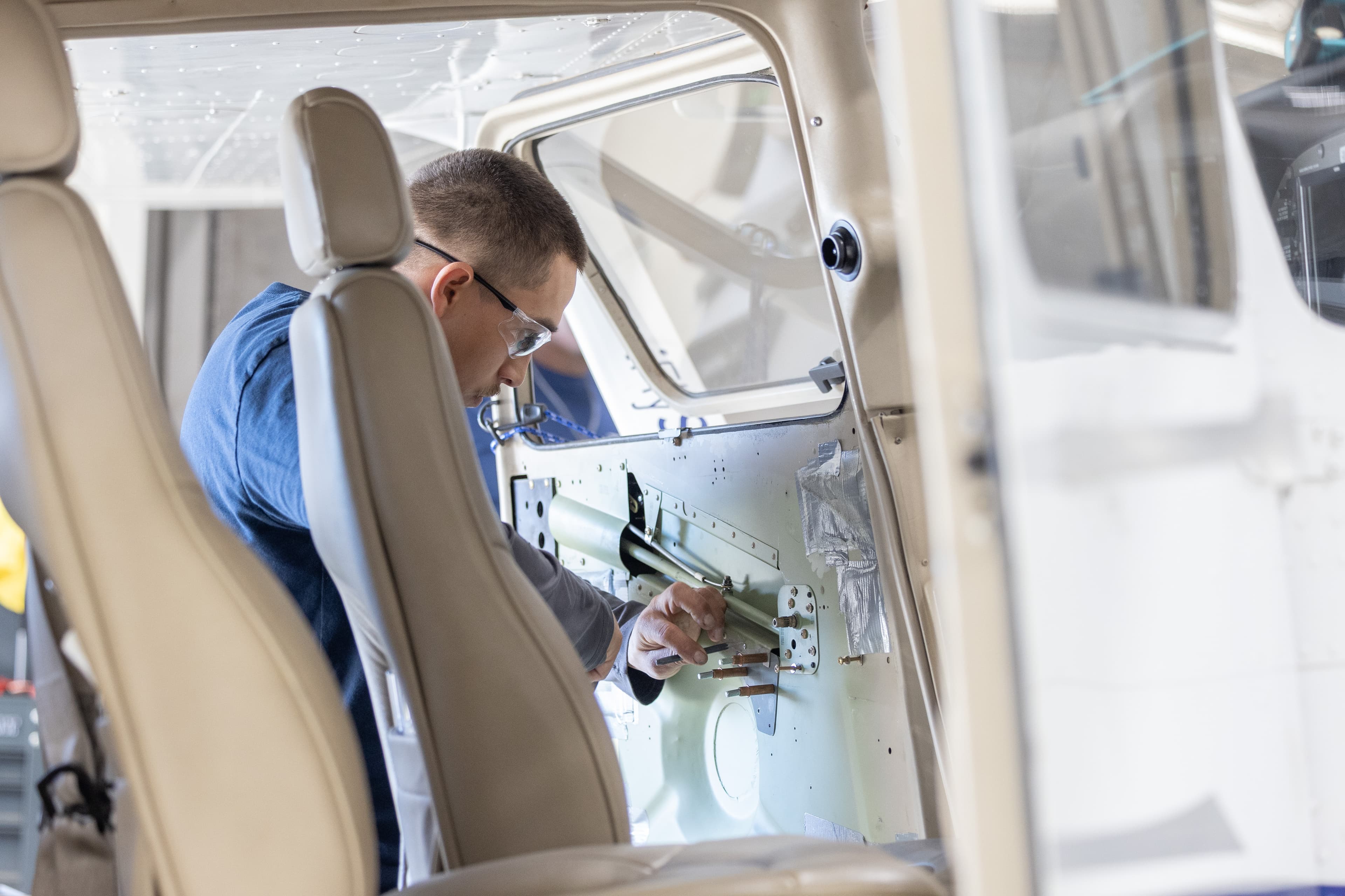 Mechanic working inside a training aircraft cabin