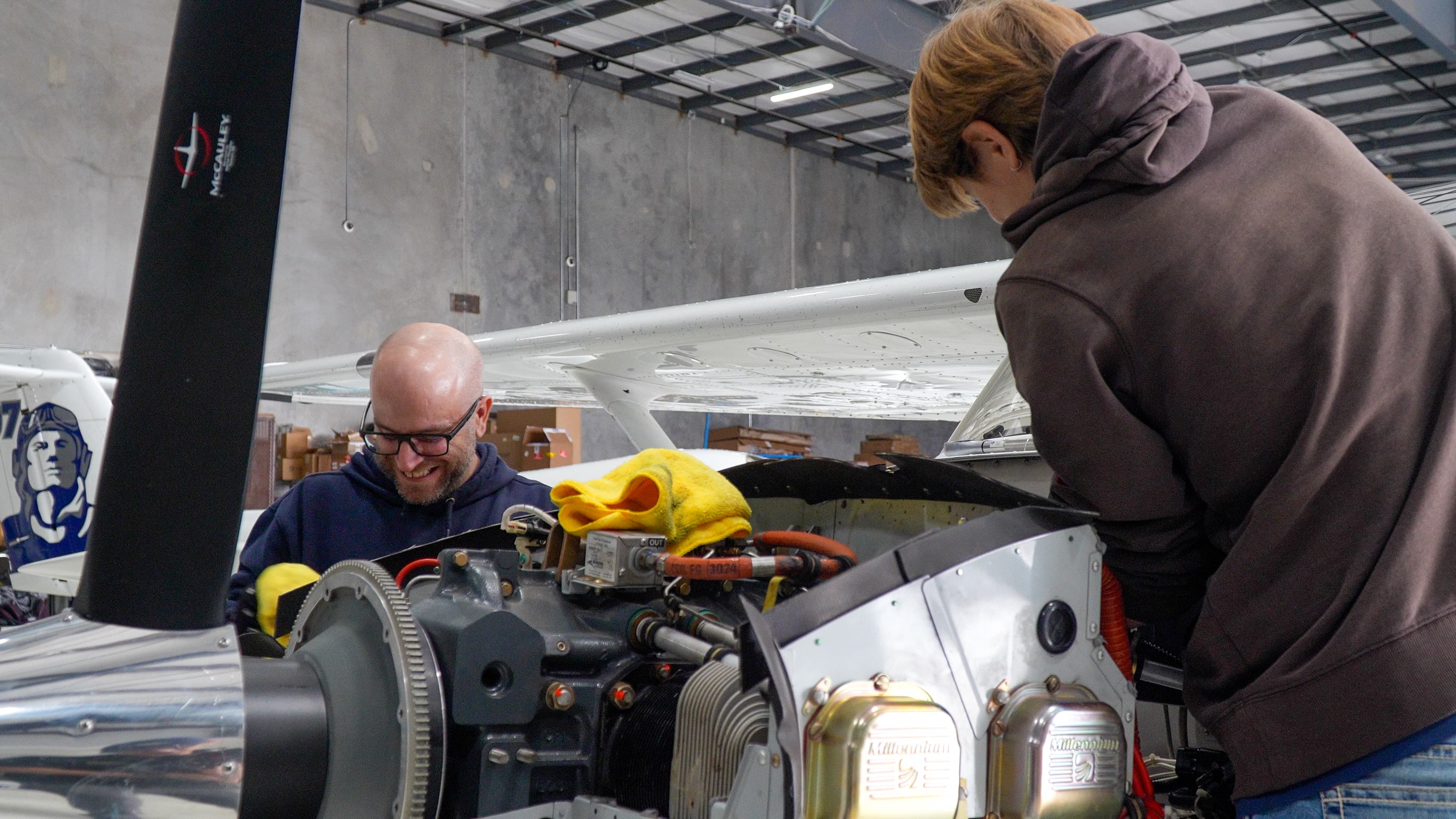 Mechanics inspecting a training aircraft